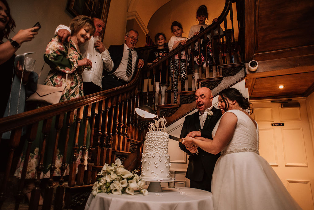 cutting the cake, Bride and groom in the cotswolds