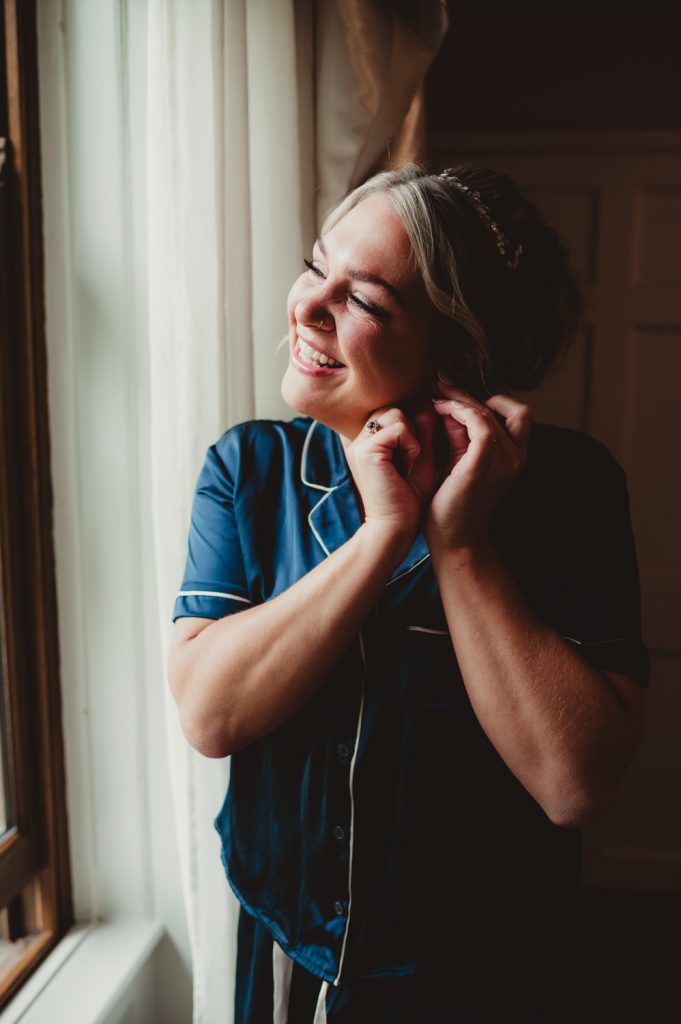 a bride putting her earings in at Hatherley manor Hotel