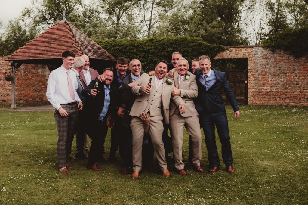 A grrom and his friends having fun and laughing at Hatherley Manor hotel