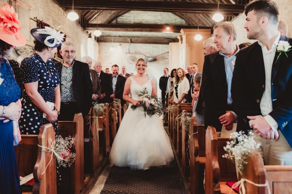 a bride walking up the aisle at boddington church