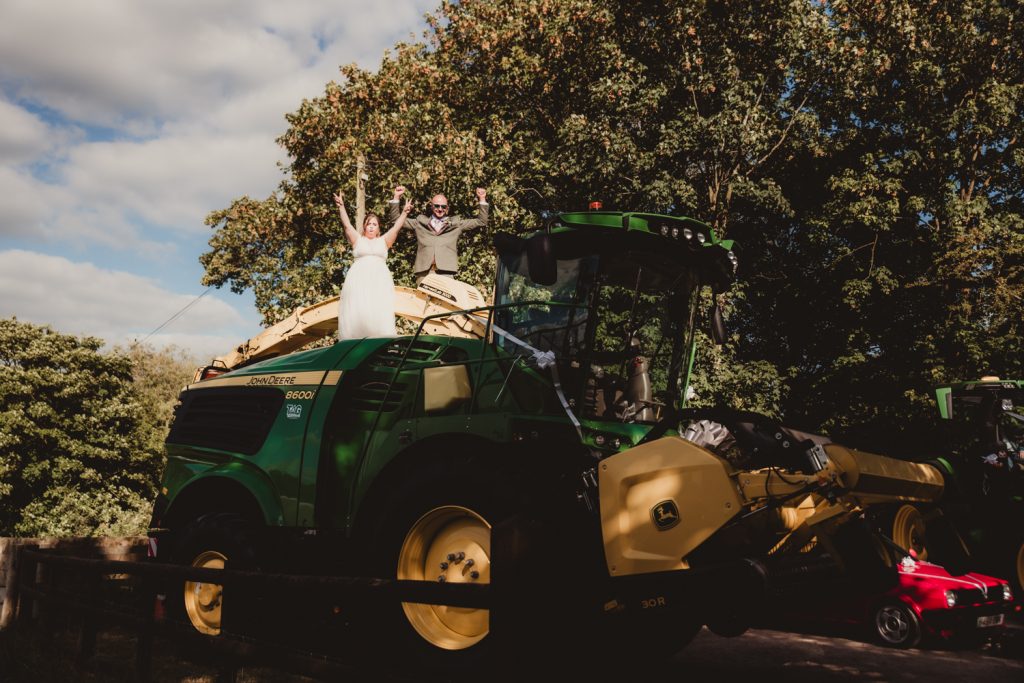 A bride and groom on top of a harvester at thier cotswolds wedding