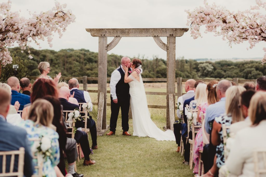 Bride and groom having first kiss at Hardwick Moat Weddings