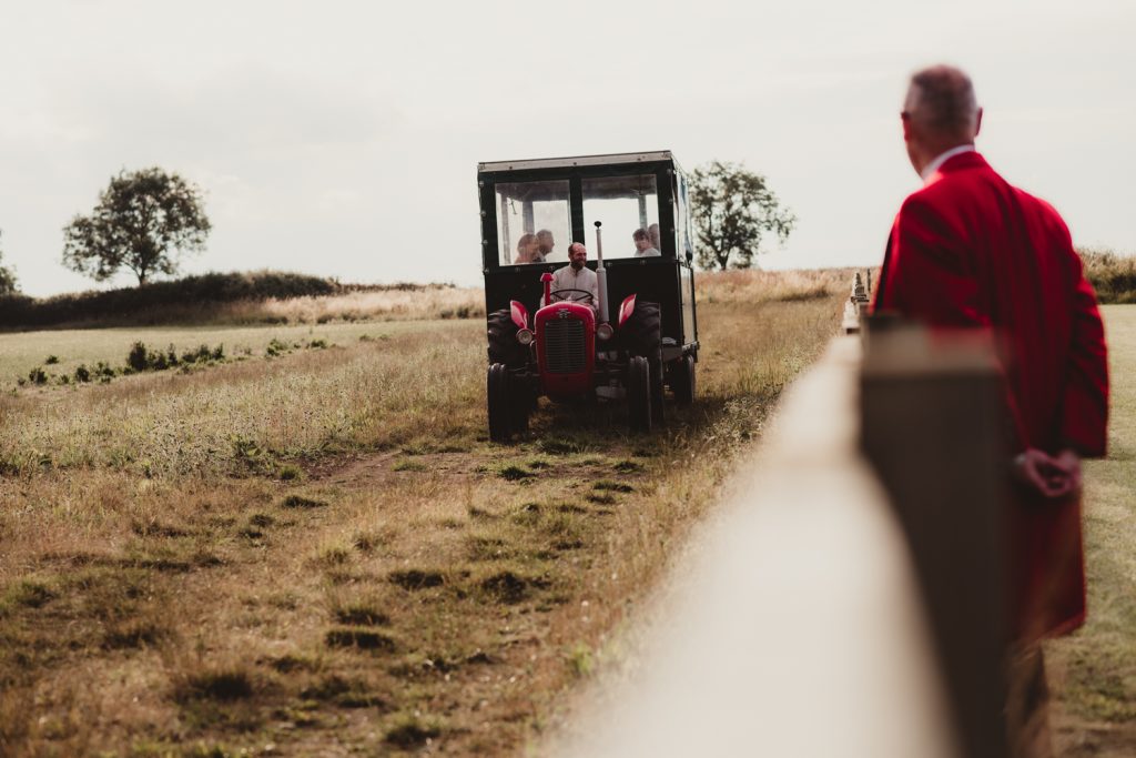 guests arriving in a tractor at Hardwick Moat Weddings