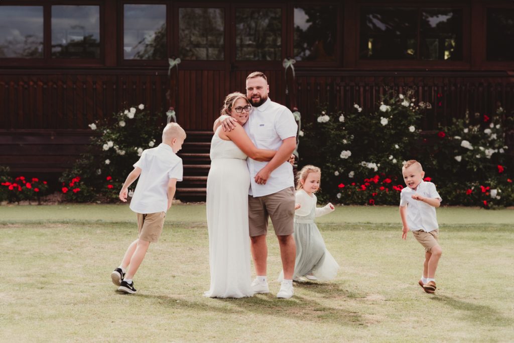 A bride and groom with their children at a cotswolds wedding