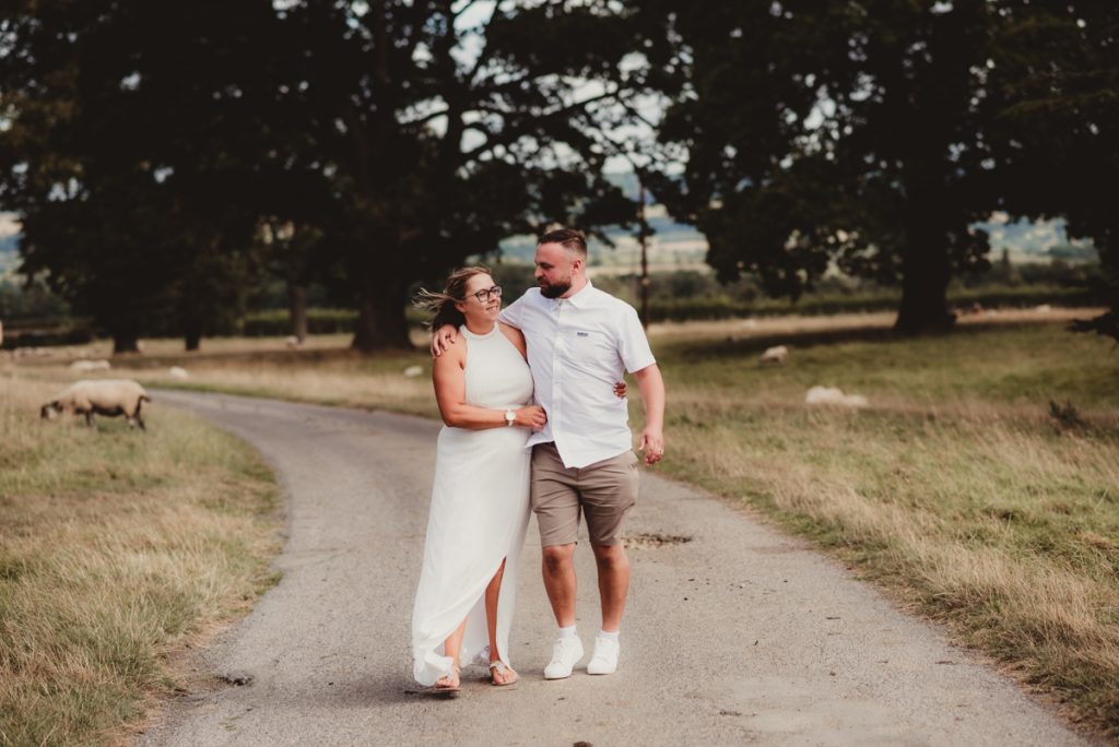 Bride and Groom taking a stroll down Dumbleton manors driveway