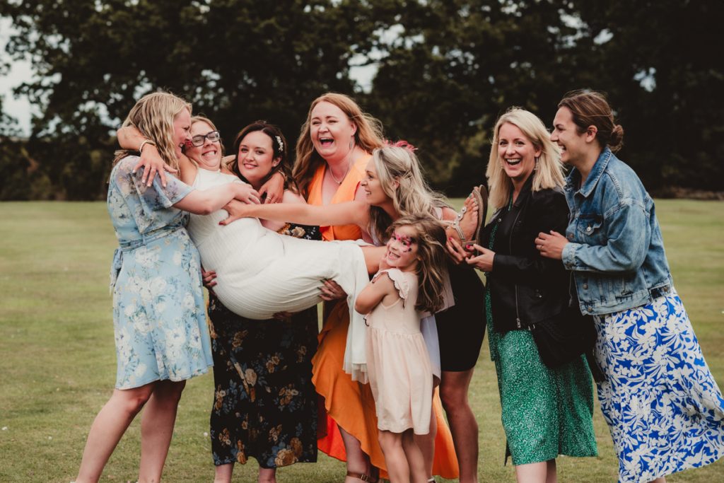 a bride being lifted up by her friends at a gloucestershire wedding