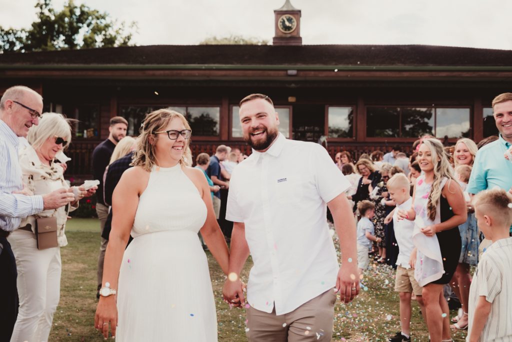 Bride and groom laughing at Dumbleton Cricket Club