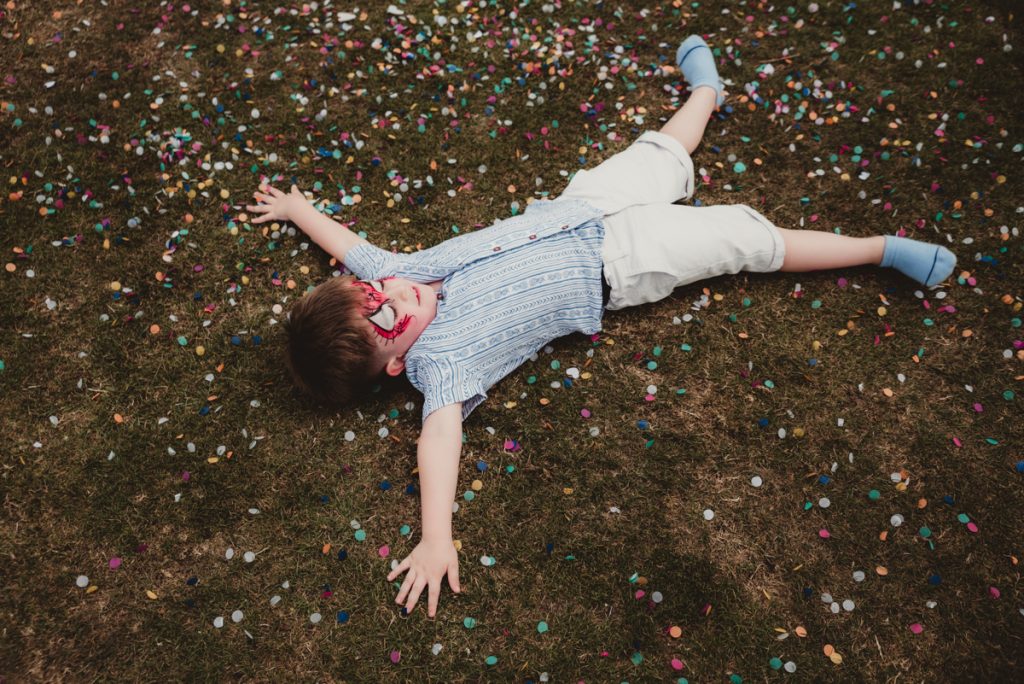 a boy making snow agels from confetti at Dumbleton cricket club