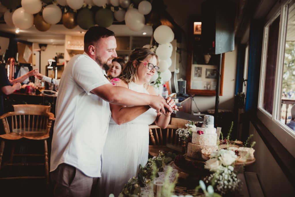 Bride and groom cutting their cheesecake at a gloucestershire wedding