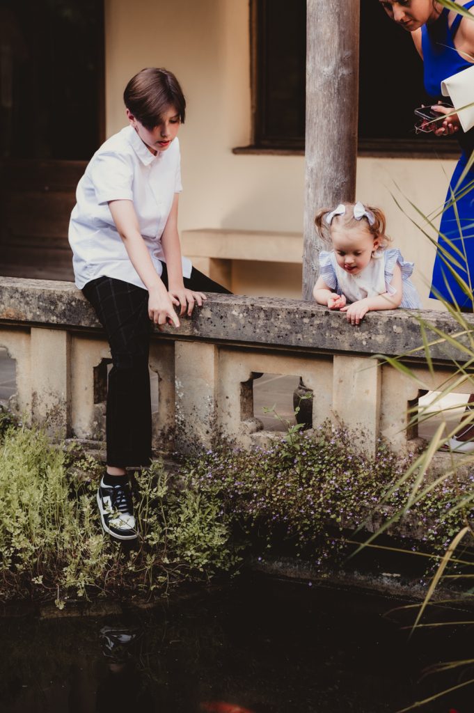 A candid moment of 2 children playing.  Captured by a Cotswolds wedding photographer at the Matara Centre