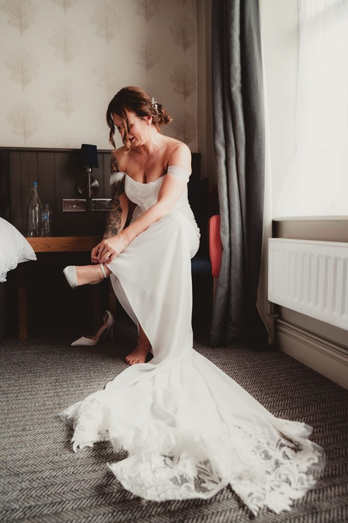 Bride putting on her wedding shoes