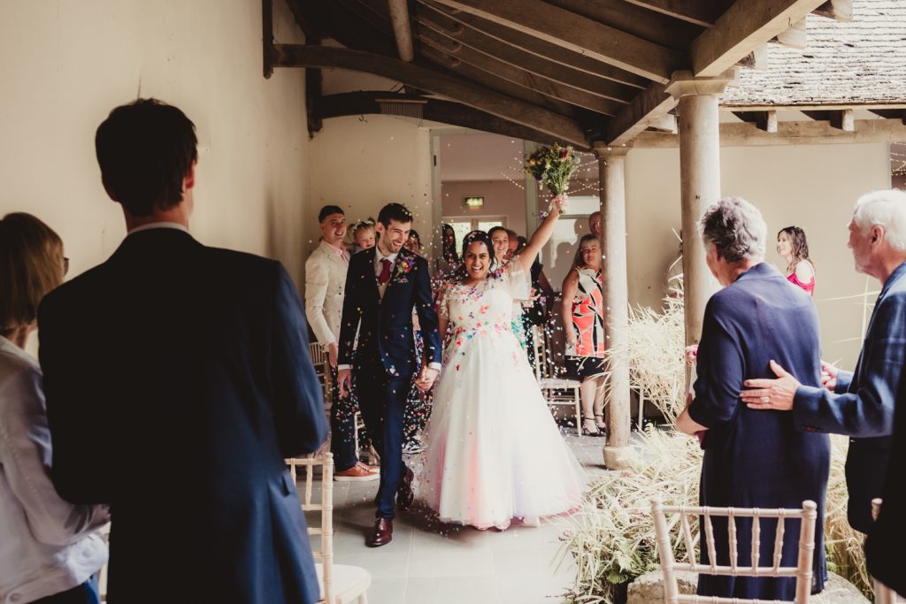 A bride and groom having confetti thrown at them just after their vows at the Matara centre