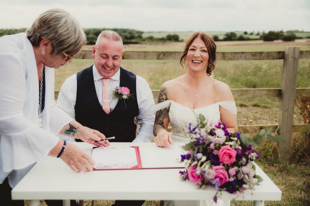 bride and groom signing register at Hardwick Moat Weddings