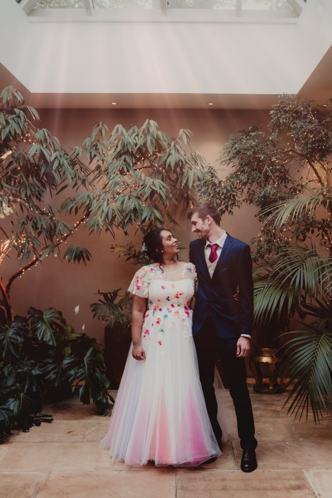 A bride and groom smiling. Amongst the greenery in the Matara Centre