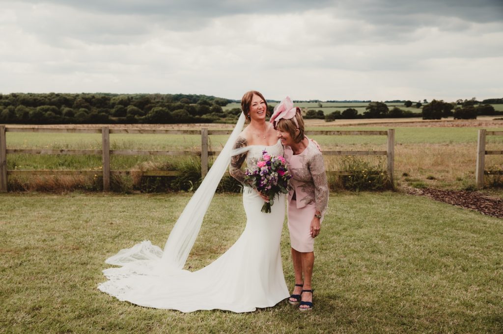 Bride and mother of the bride laughing at Hardwick Moat Weddings